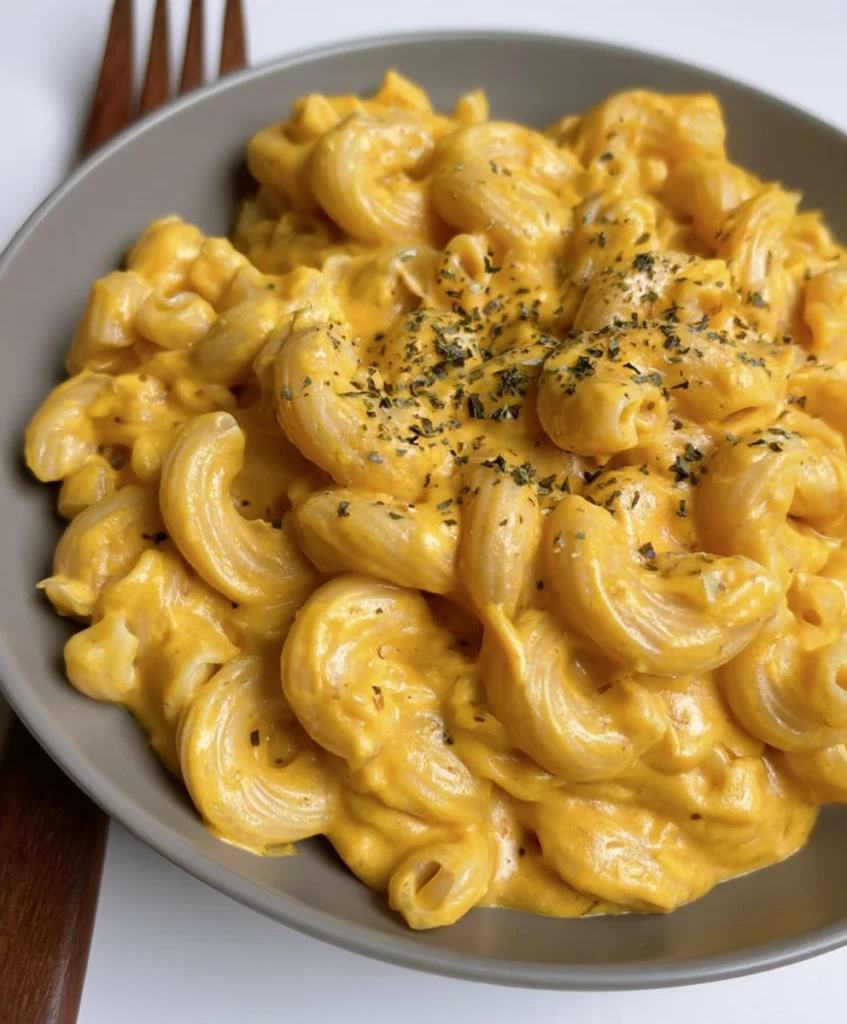 Creamy vegan mac and cheese topped with dried herbs on a plate